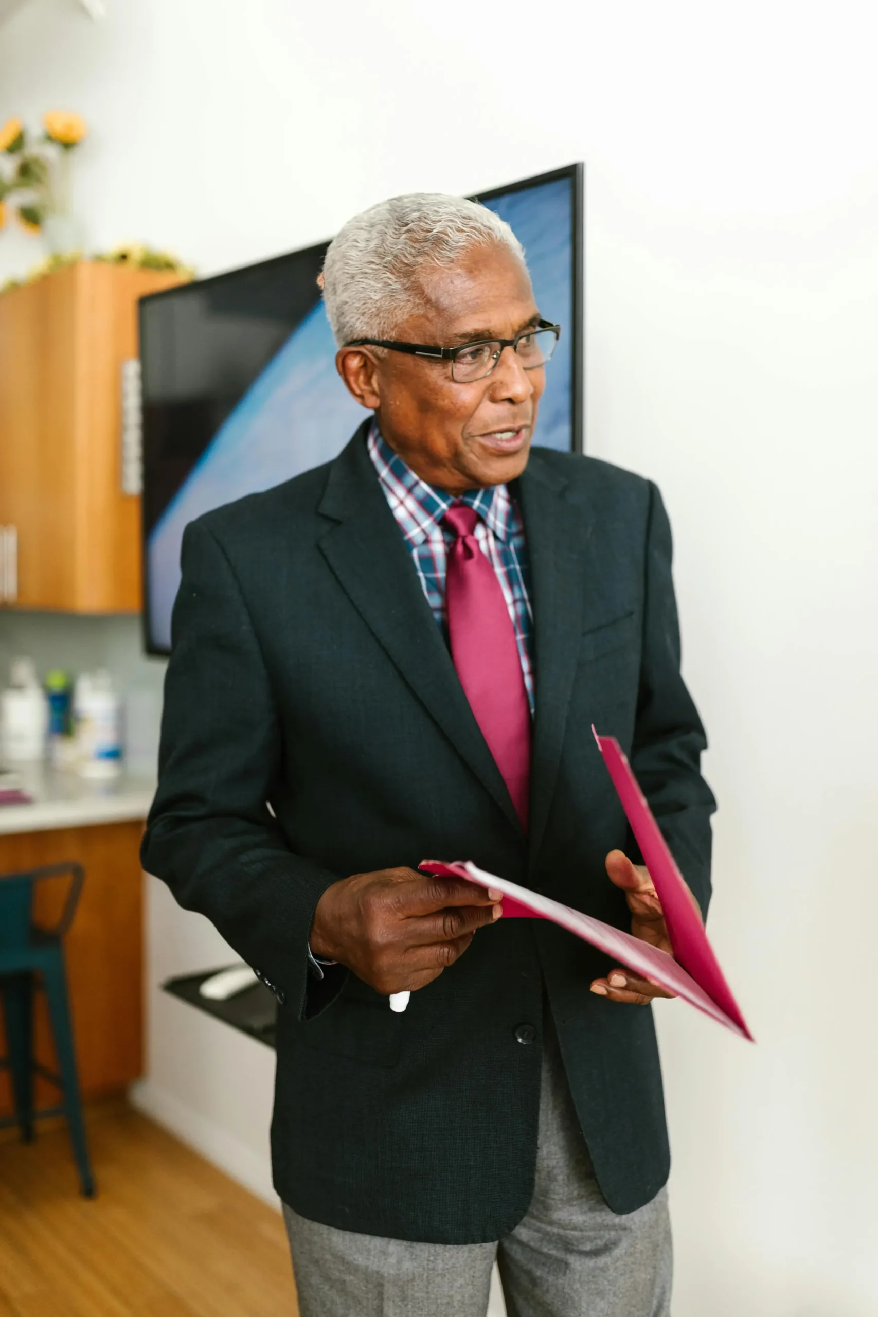 Older man in suit, holding folder